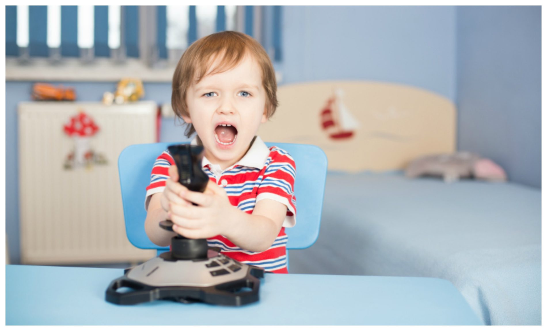 A young child playing with a joystick and appearing to be happy or vocalizing.